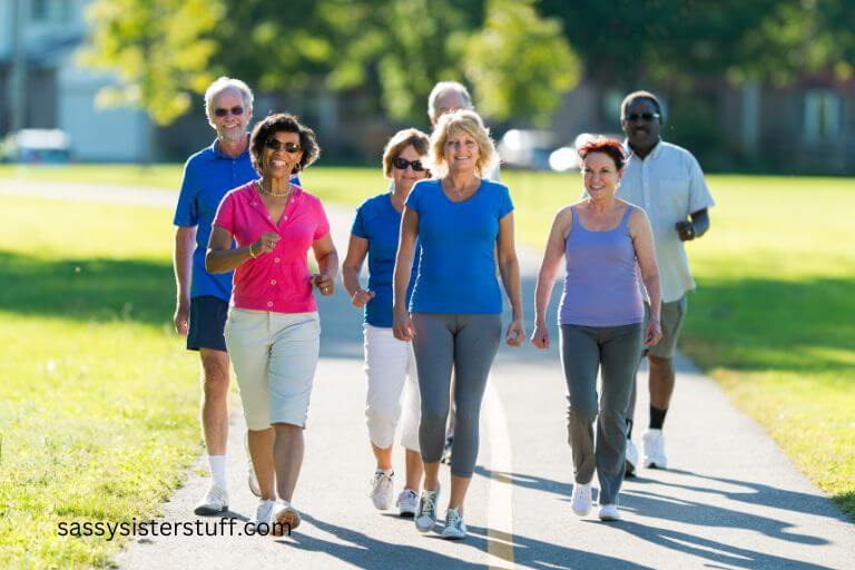 a group of 7 older men and women take a brisk walk together on a sunny spring day.