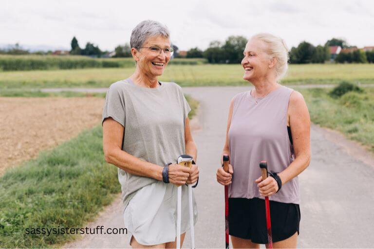 two older women use walking sticks to take a walk because they know the many benefits of walking for seniors and aging adult.