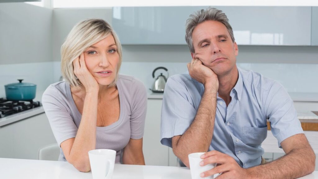 couple looking bored at table with coffee cups