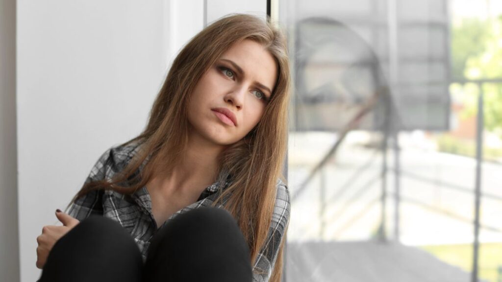 woman leaning on window upset