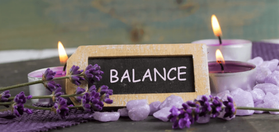 finding balance sign with purple flowers and candles