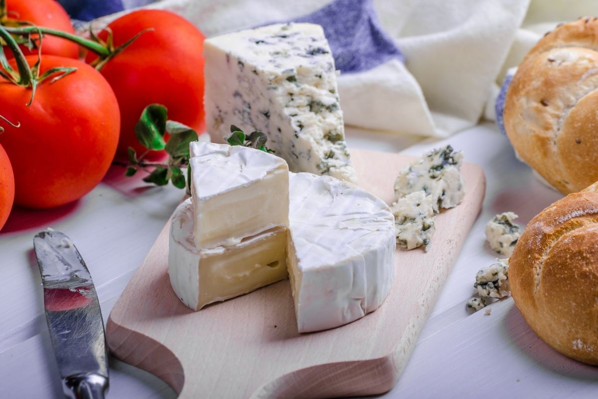 gourmet cheeses and bread and vine tomatoes arranged in a nice presentation