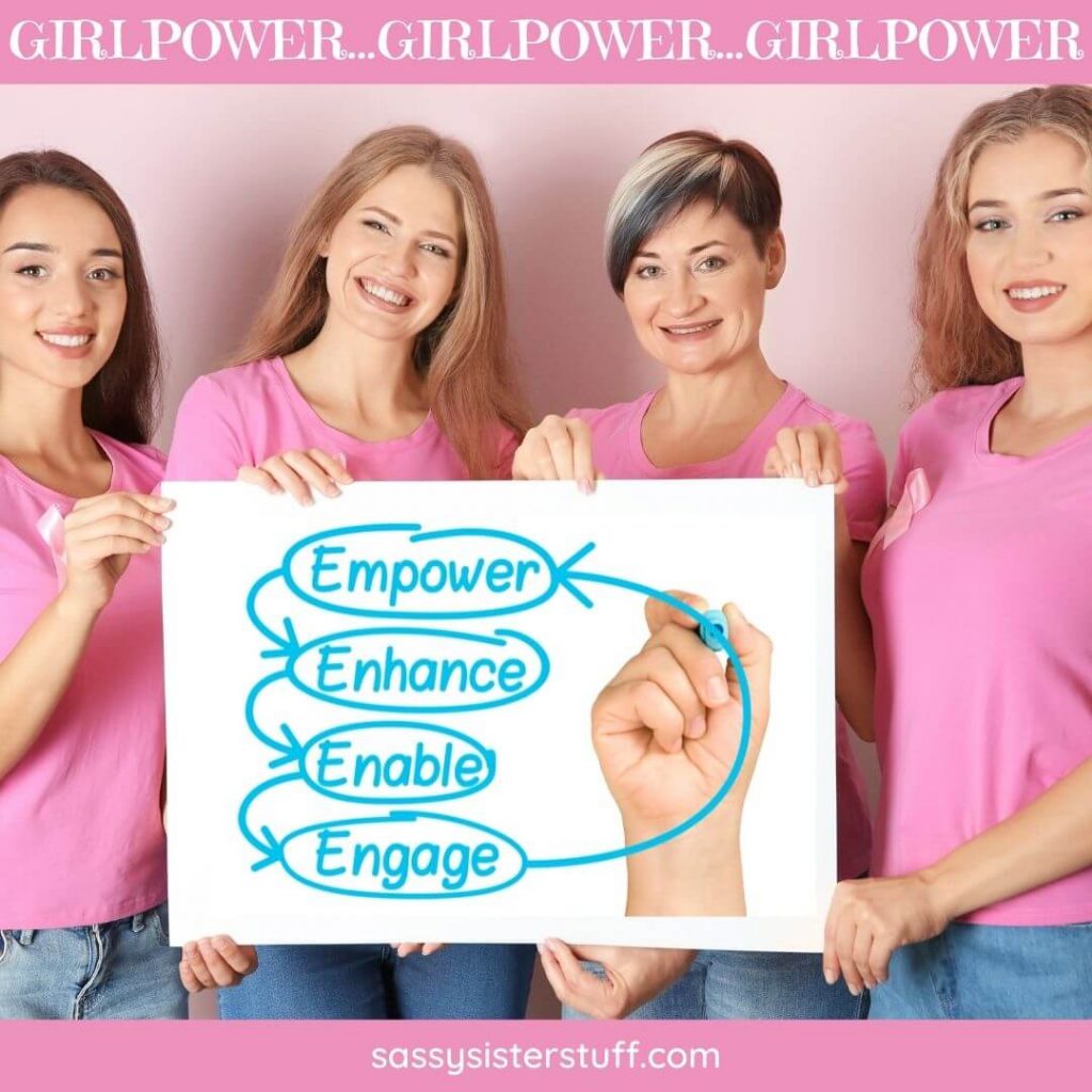 four happy ladies in pink shirts showing a sign for empowerment and girlpower