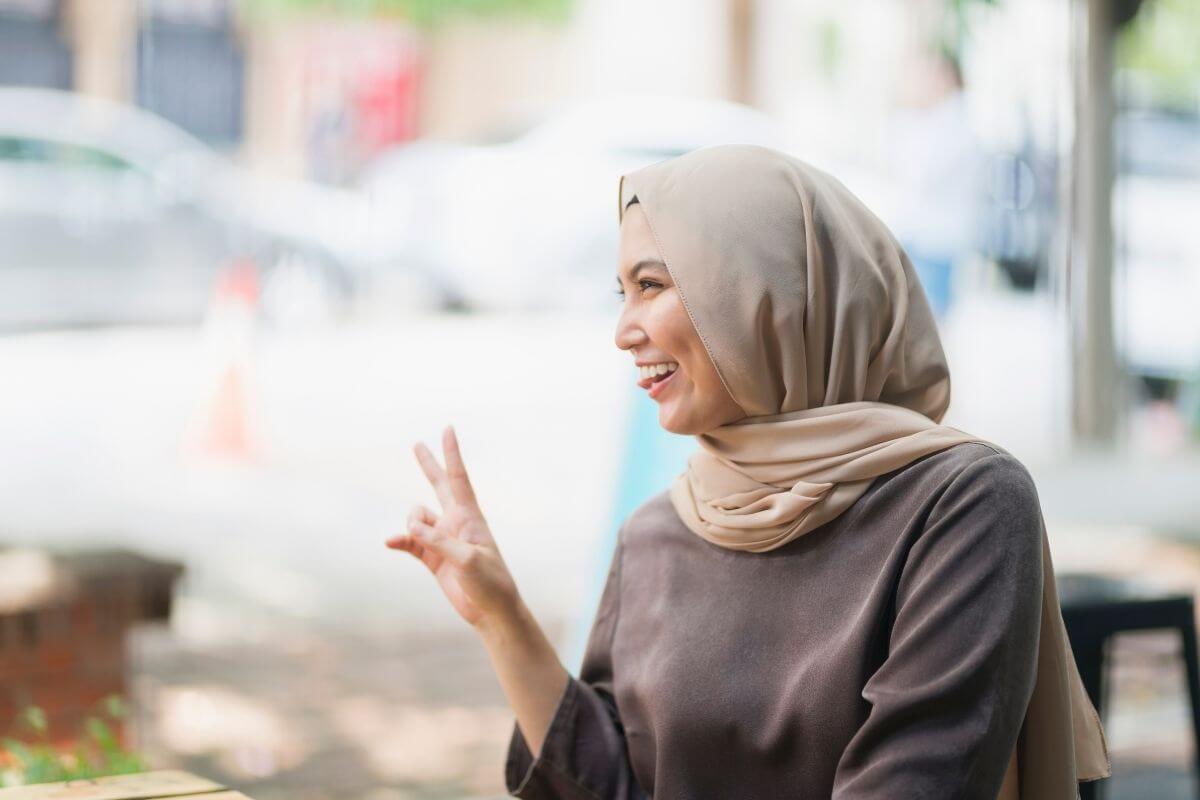 happy woman holds up two finger for a peace sign