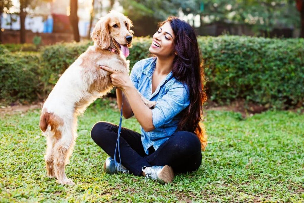 woman playing with her dog on the lawn