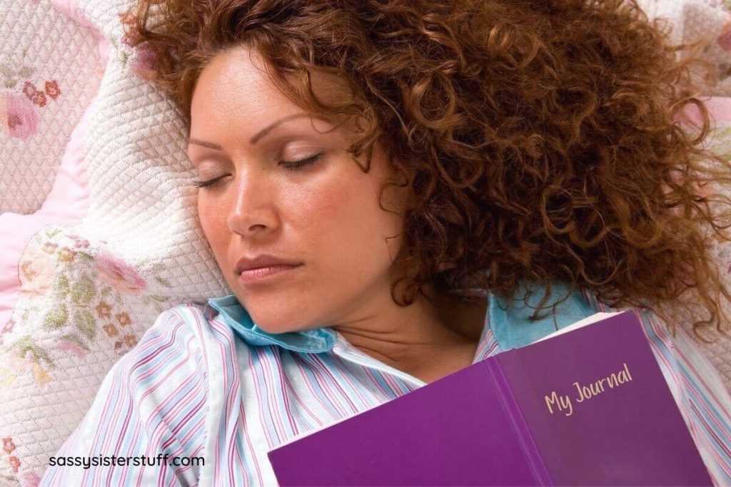 woman has fallen asleep with a journal on her chest