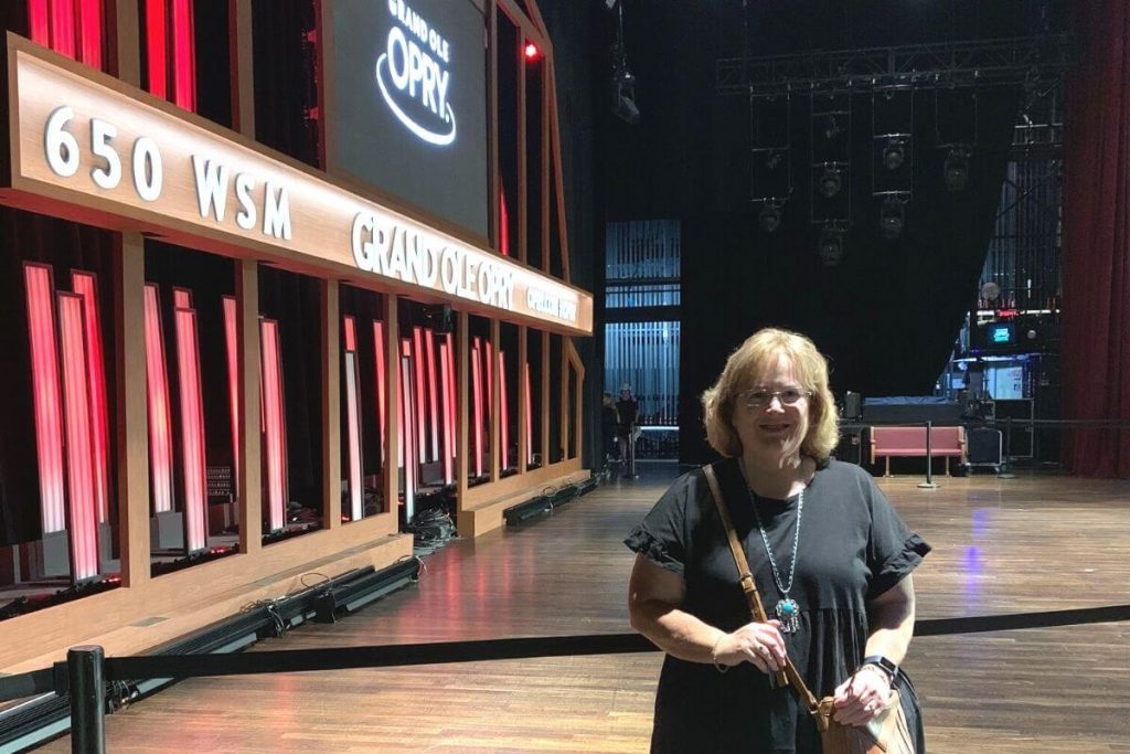 happy tourist standing on stage during a backstage tour of the Grand Ole Opry