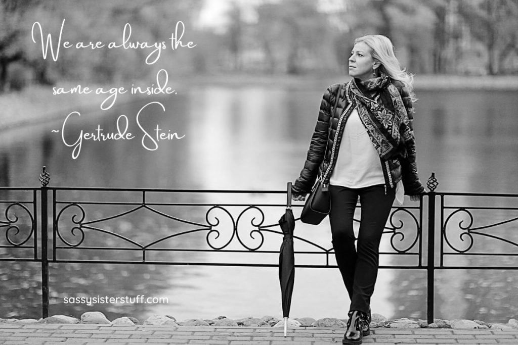 middle aged woman leaning against a fence with a quote about aging