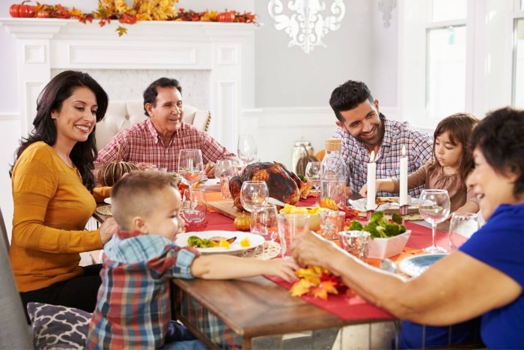 a multi-generational family sharing a simple Thanksgiving dinner of turkey and sides