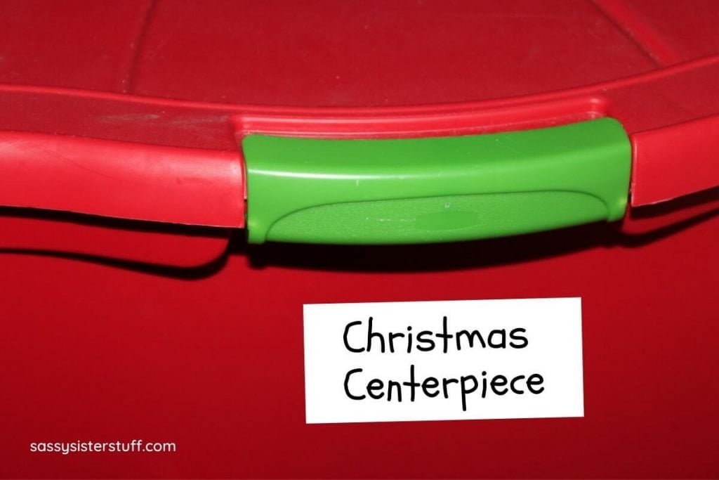 a red and green bin labeled Christmas centerpiece showing how someone is getting organized for the holidays