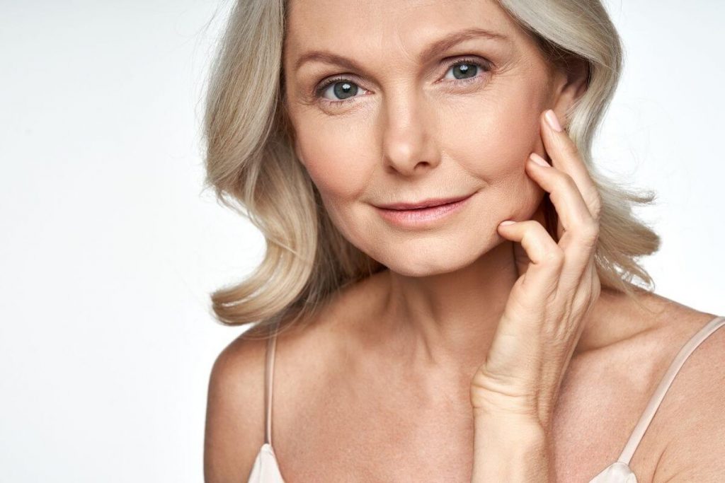 woman with short blonde hair and glowing skin over 50