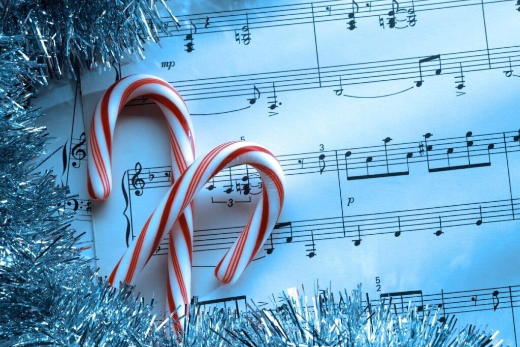 a sheet of music and two candy canes with silver tinsel