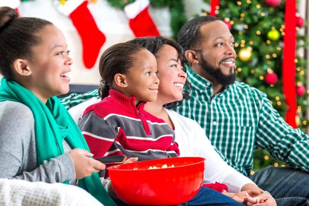 a family of four with mom dad son and daughter show how to get in the christmas spirit by watching holiday movies