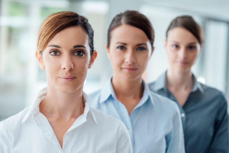 cover image for empowering words for women with three empowered women standing in a line one behind the other smiling confidently at the camera