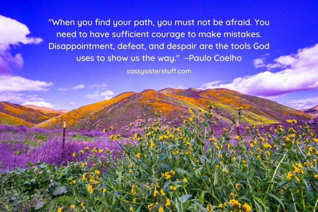 a flower covered mountain against a beautiful bright blue sky and an inspirational quote about life