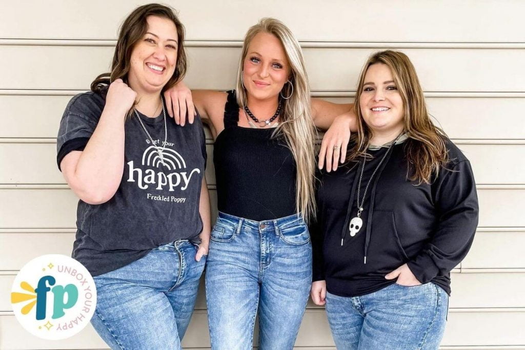 three happy women of different sizes modeling jeans and black tops from freckled poppy boutique clothes women love