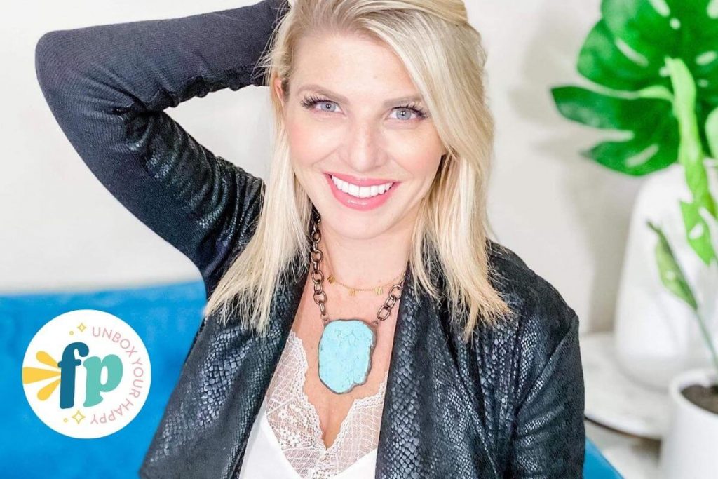 owner of freckled poppy boutique clothes women love smiles at the camera wearing a beautiful turquoise stone necklace white camisole and black snakeskin jacket