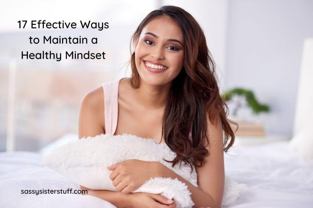 a beautiful woman lays on her stomach hugging a fuzzy white pillow and smiling at the camera and the title 17 effective ways to maintain a healthy mindset