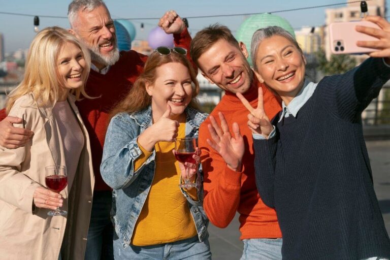 five happy middle aged men and women take a selfie together