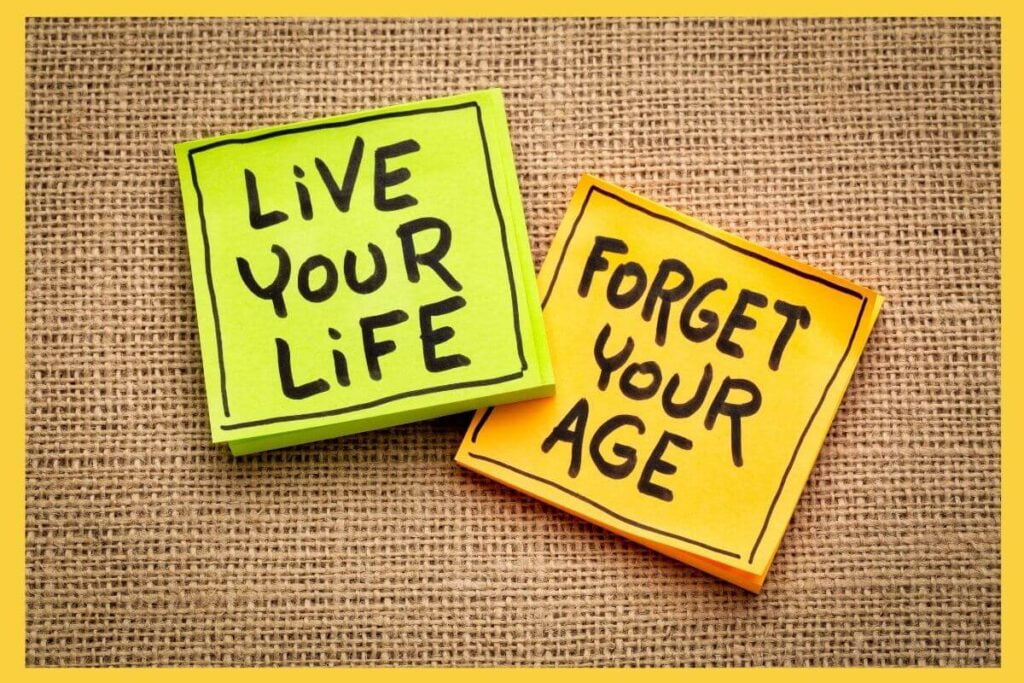 green post it notes that live your life and yellow post it notes that say forget your age laying on a piece of burlap