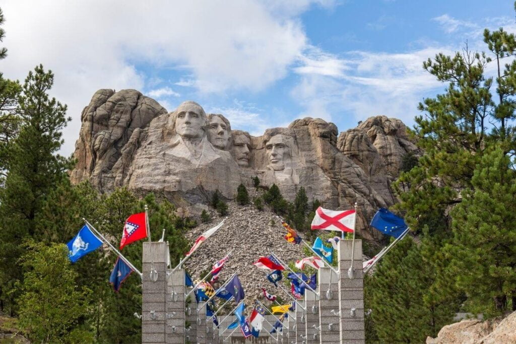 a photo of mount rushmore and flags to help visitors plan an adventure vacation to the monument