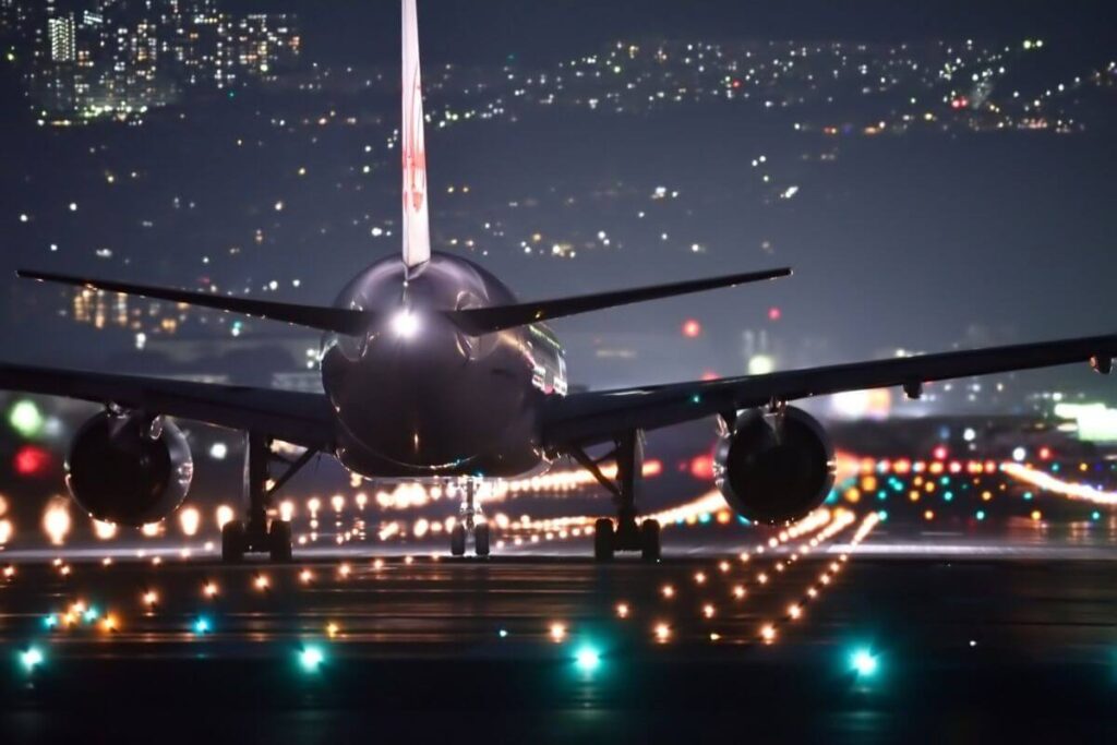 an night time photo of an airplane sitting on the runway with lots of lights getting ready to take off