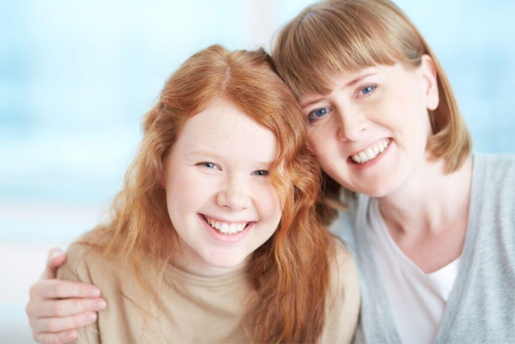 a happy mom and pre teen daughter who just keep smiling to make the world a better place