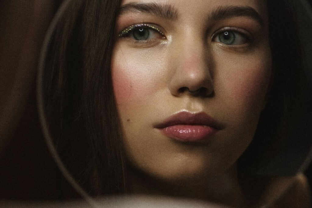 a close-up photo of a pretty dark haired woman reflecting on questions to ask yourself about the past year