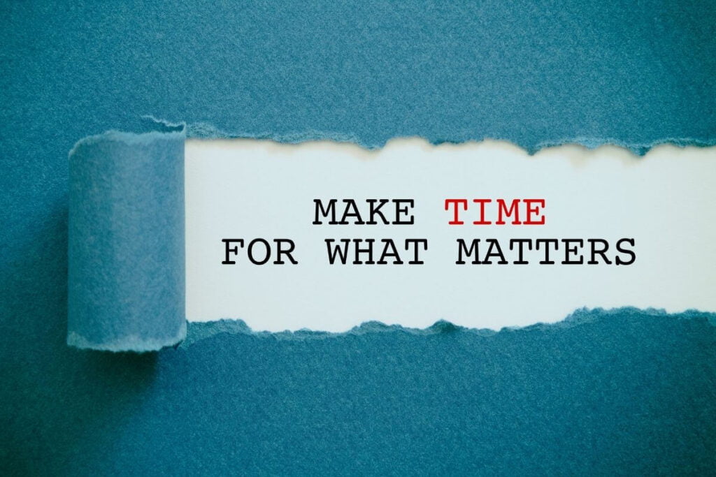 a dark teal piece of paper torn to reveal the words underneath that say make time for what matters