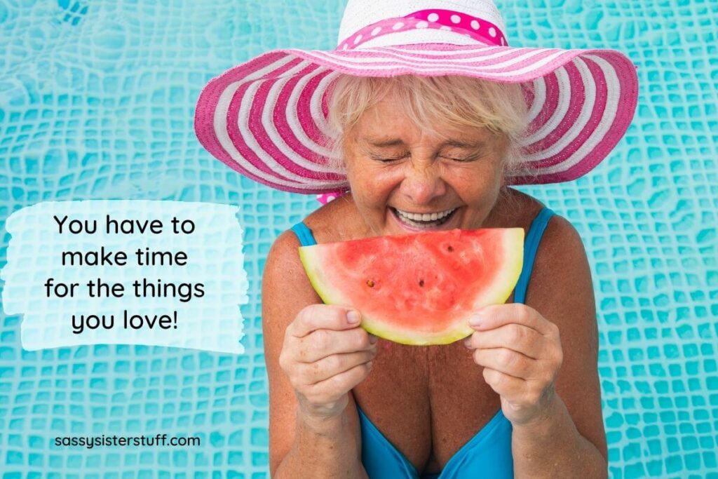 a silly middle aged woman with a bright pink hat on wearing a pretty blue bahing suit getting ready to bite into a piece of yummy watermelon and the words you have to make time for the things you love