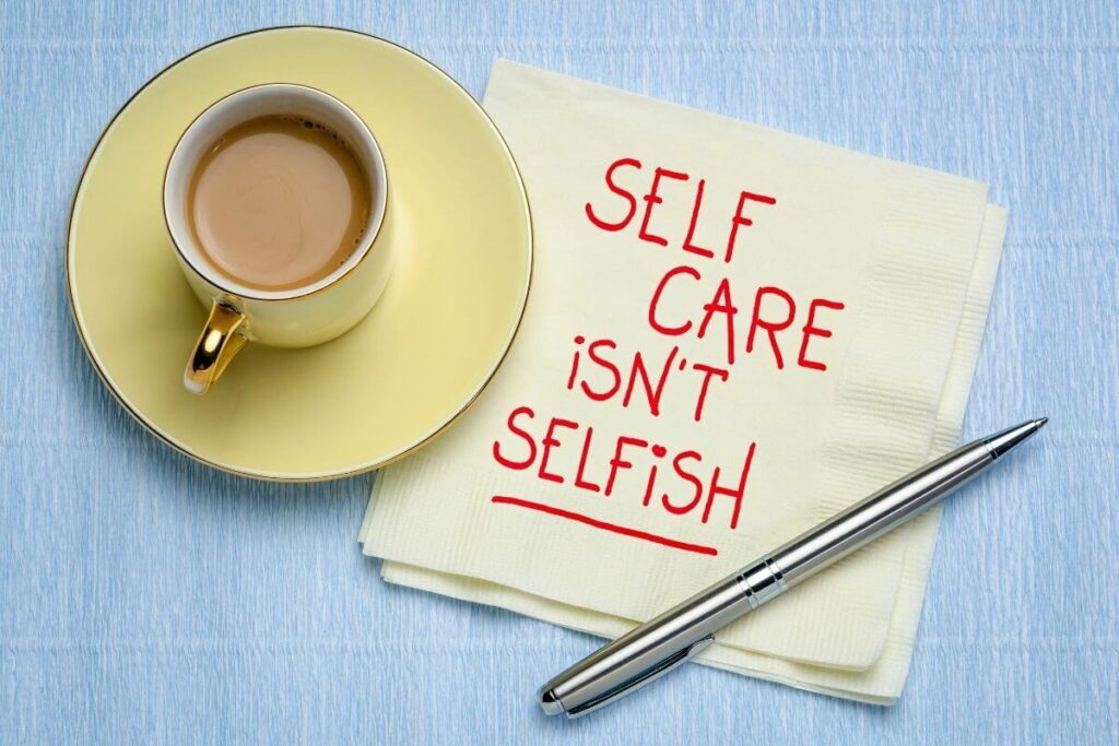 top view of a yellow cup and saucer with a napkin laying next to it that says self care isnt selfish