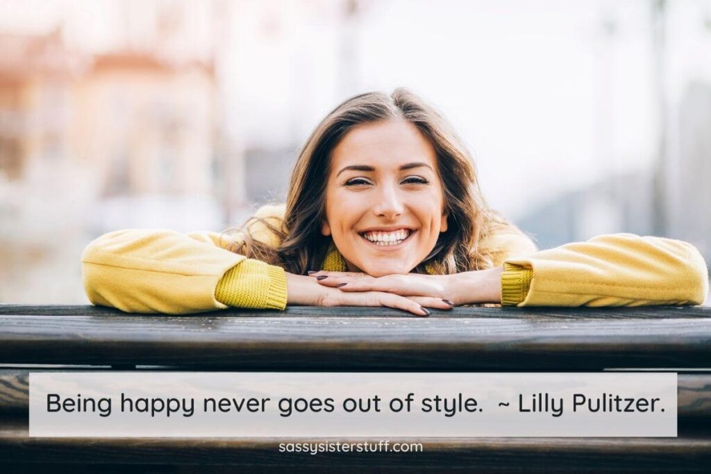 a beautiful happy young woman rest her chin on her arms on top of a wooden fence and a choose happiness quote