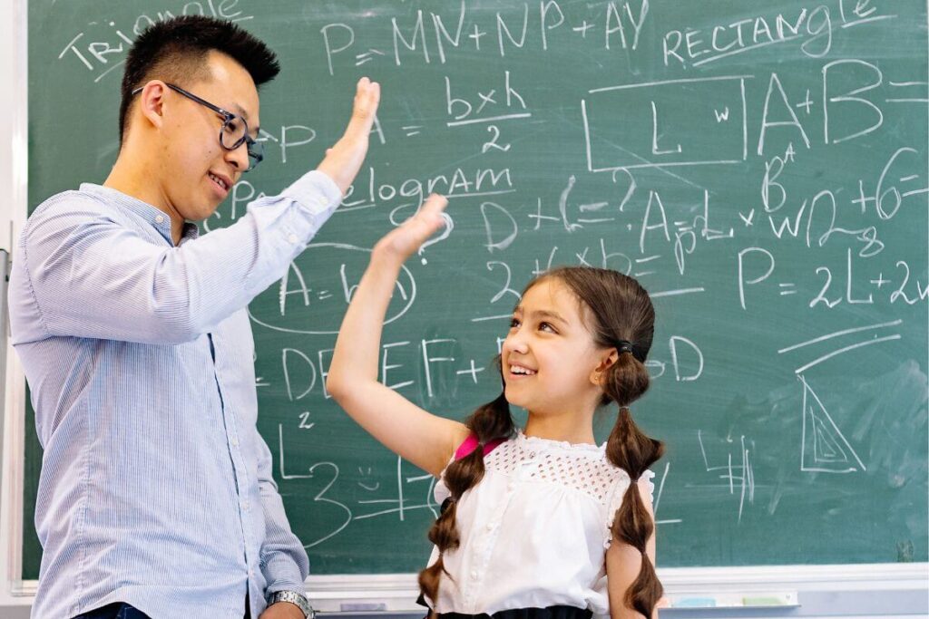 a teacher gives a little girl high five after saying things all kids need to hear about doing math problems correctly