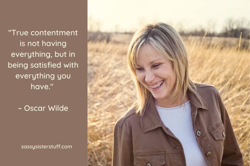 a middle aged blonde woman laughs as she stands in a golden field of wheat plus a quote from oscar wilde about true contentment