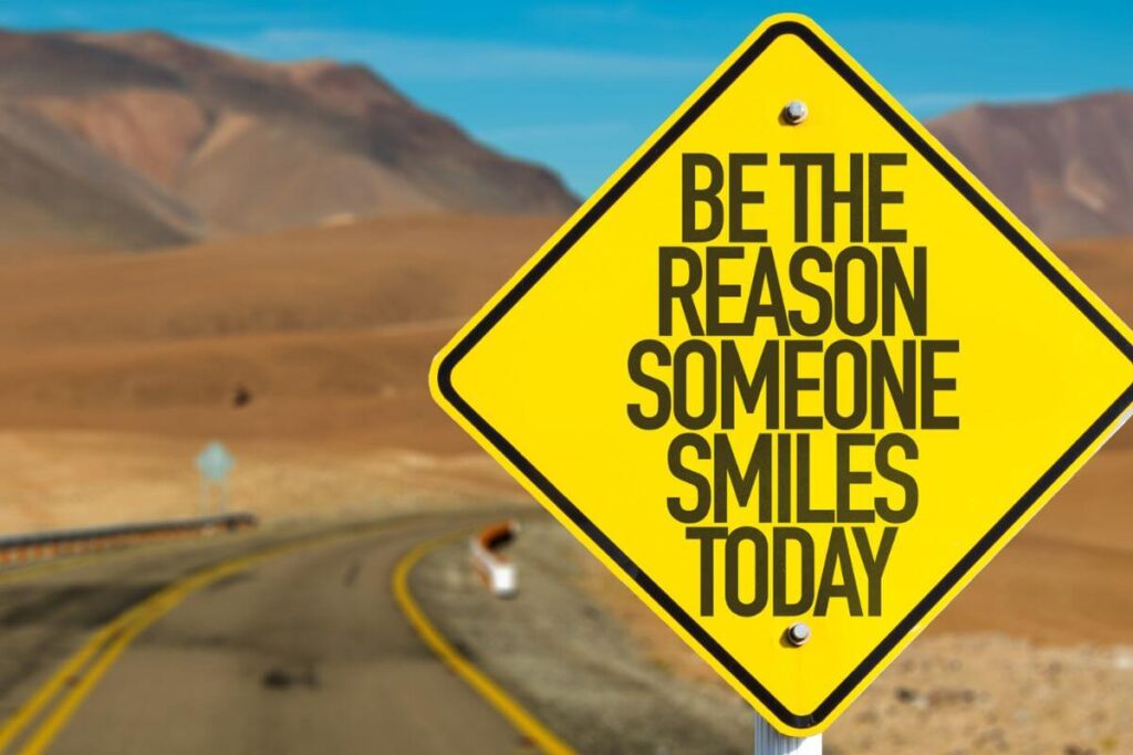 a road sign that says be the reason someone smiles today