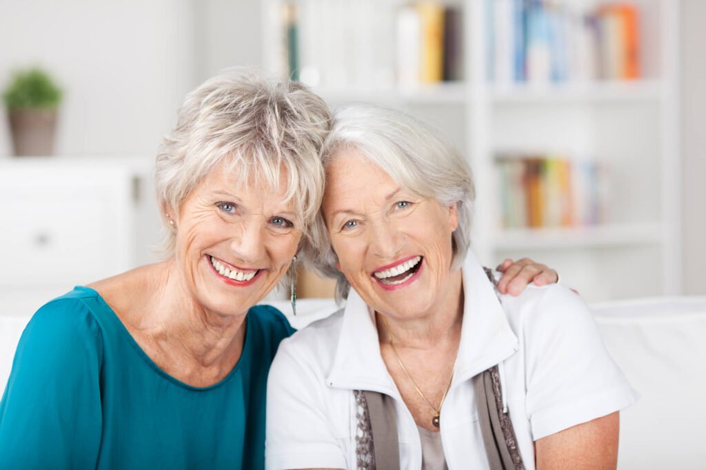 two middle aged hard working women smile for a camera