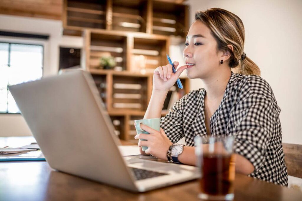 a remote worker uses her laptop on her desk in her home office