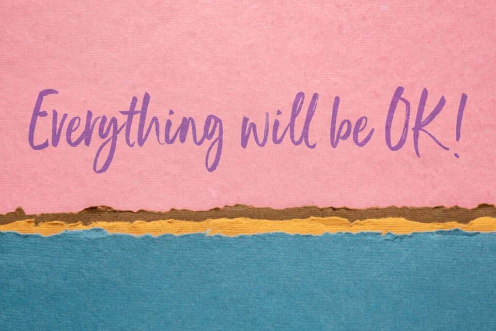 everything will be ok! Written in cursive on a pick and blue background