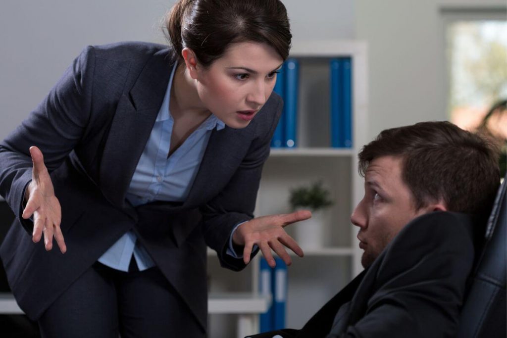 a female business woman humiliates and bullies a male coworker