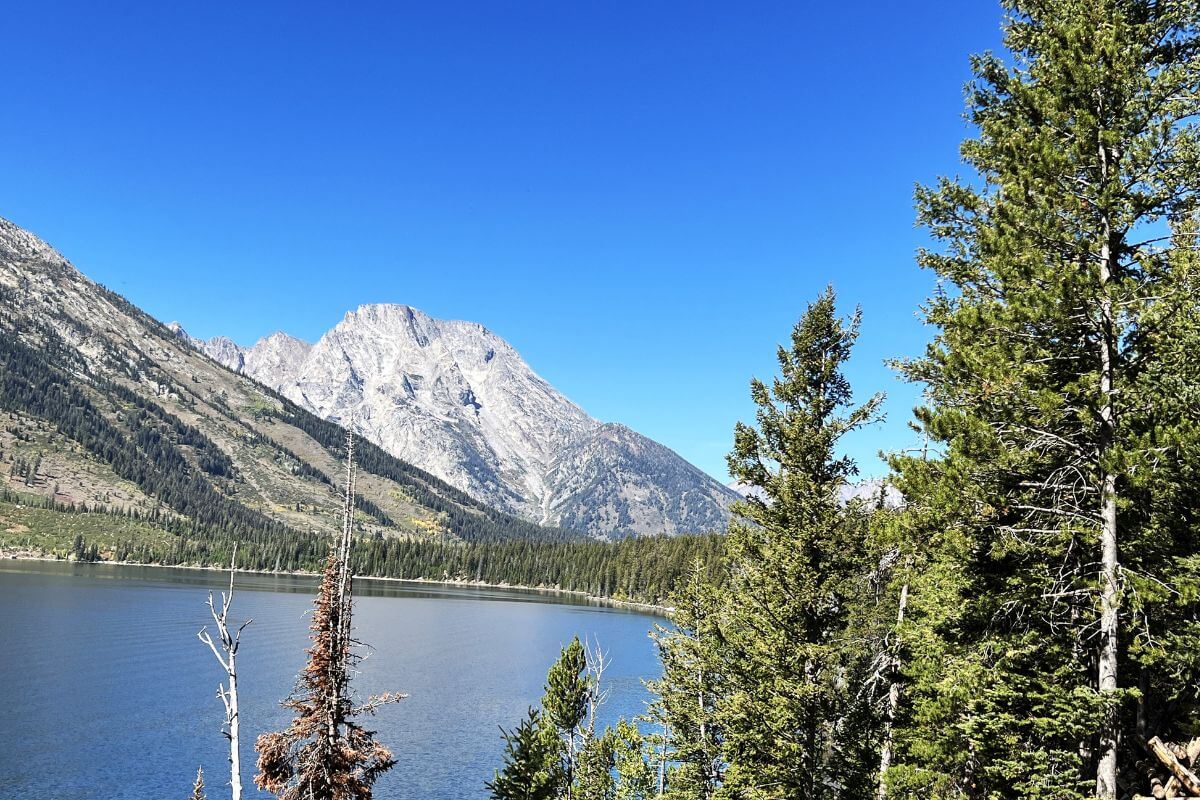 a mountain with a lake at the base sits against a bright blue sky