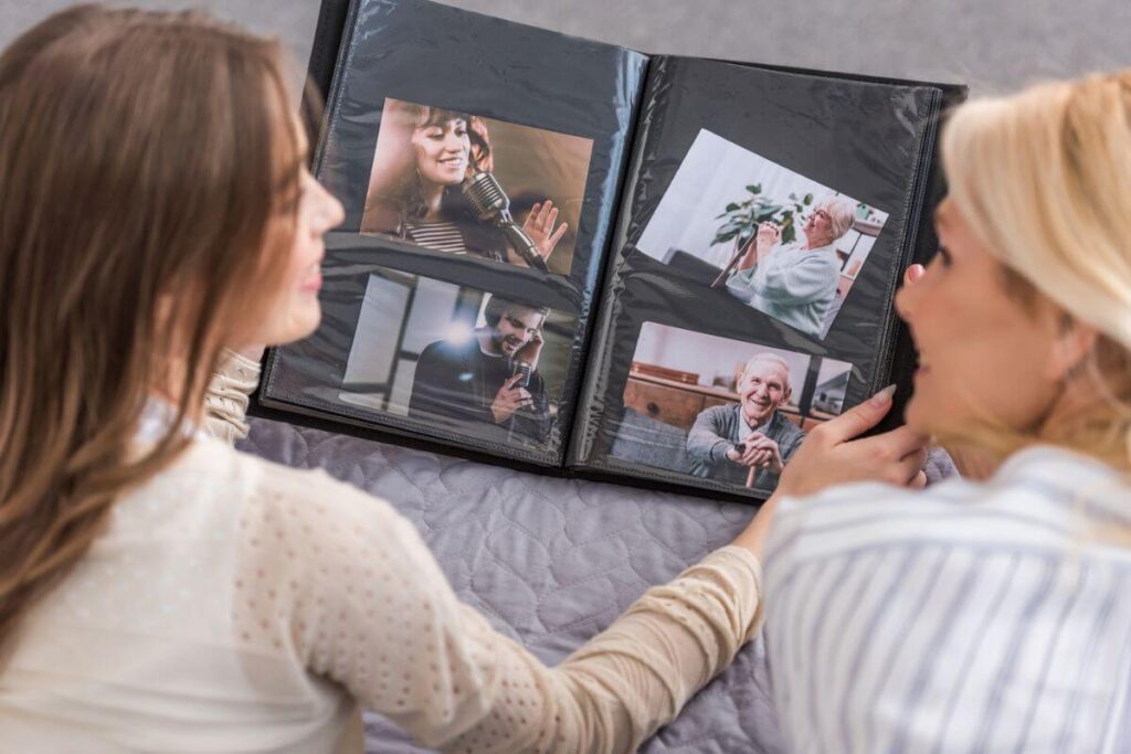 two grown women look through a photo album together enjoying the memories of their lives