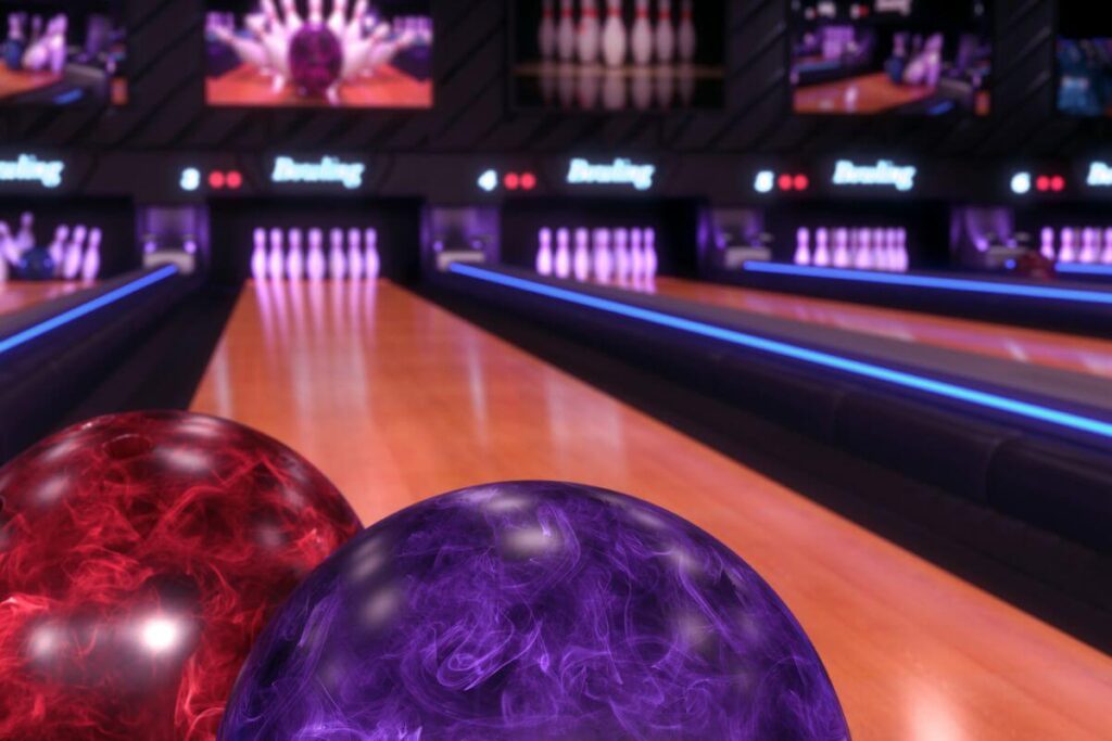 a bowling alley lane, pins, and balls lit up with red and purple lights for a special bowling event for women