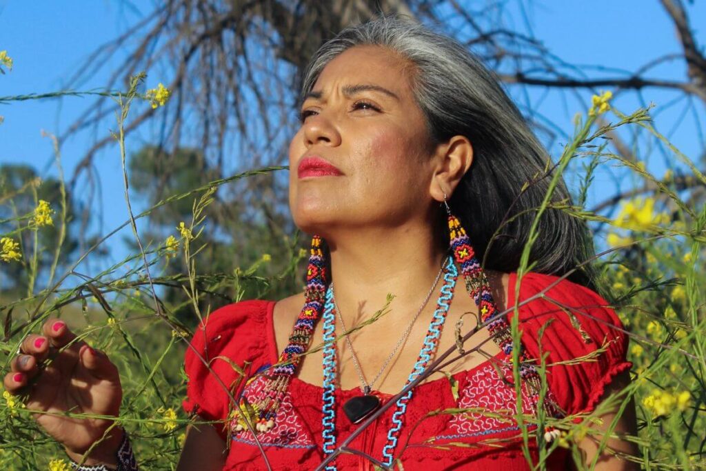 a beautiful middle aged Indian woman glances into the sky as she reflects on her personal growth journey