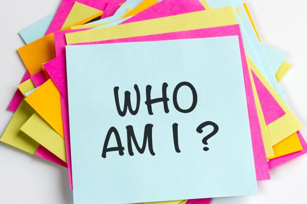 a pile of sticky notes lay on a table with the question WHO AM I?