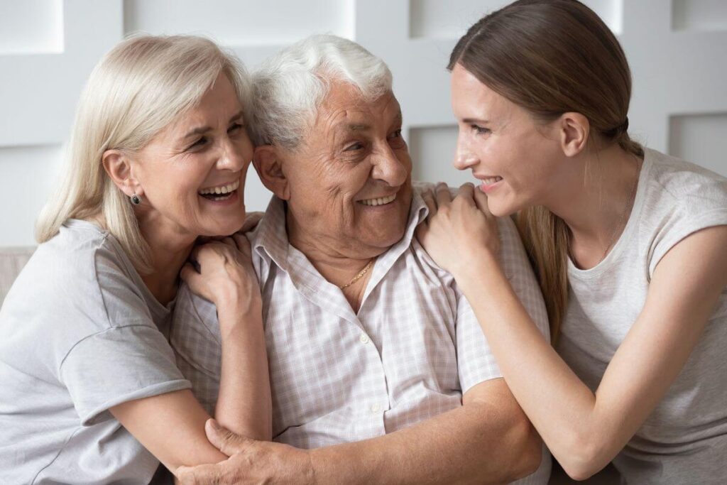 a lovely adult daughter sits and socializes with her elderly parents to show them love and attention