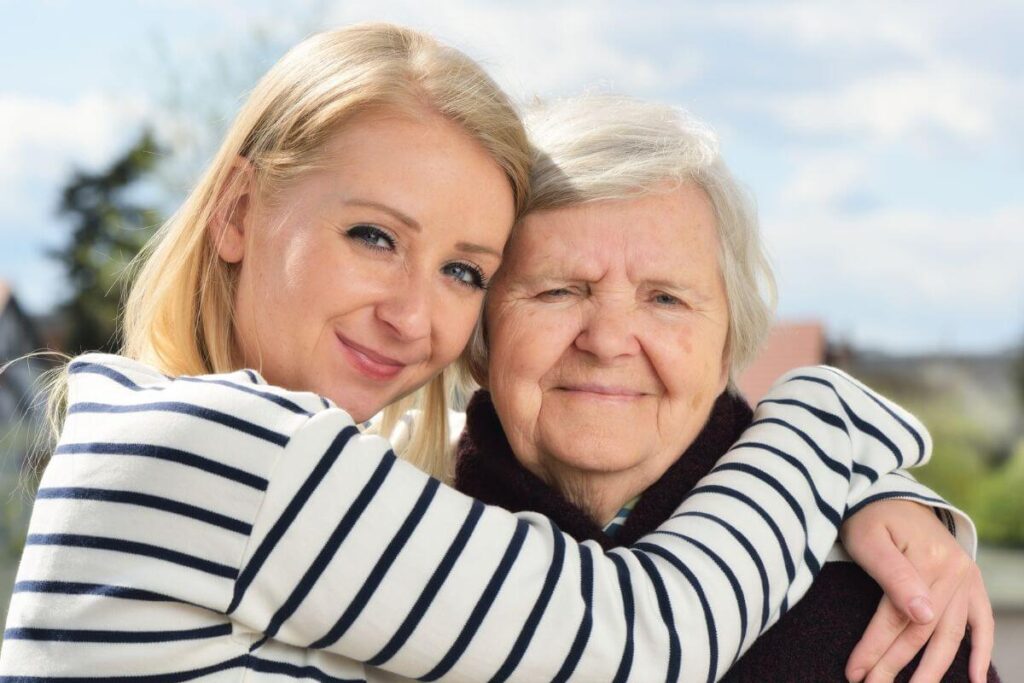 lovely adult daughter hugs her elderly mother