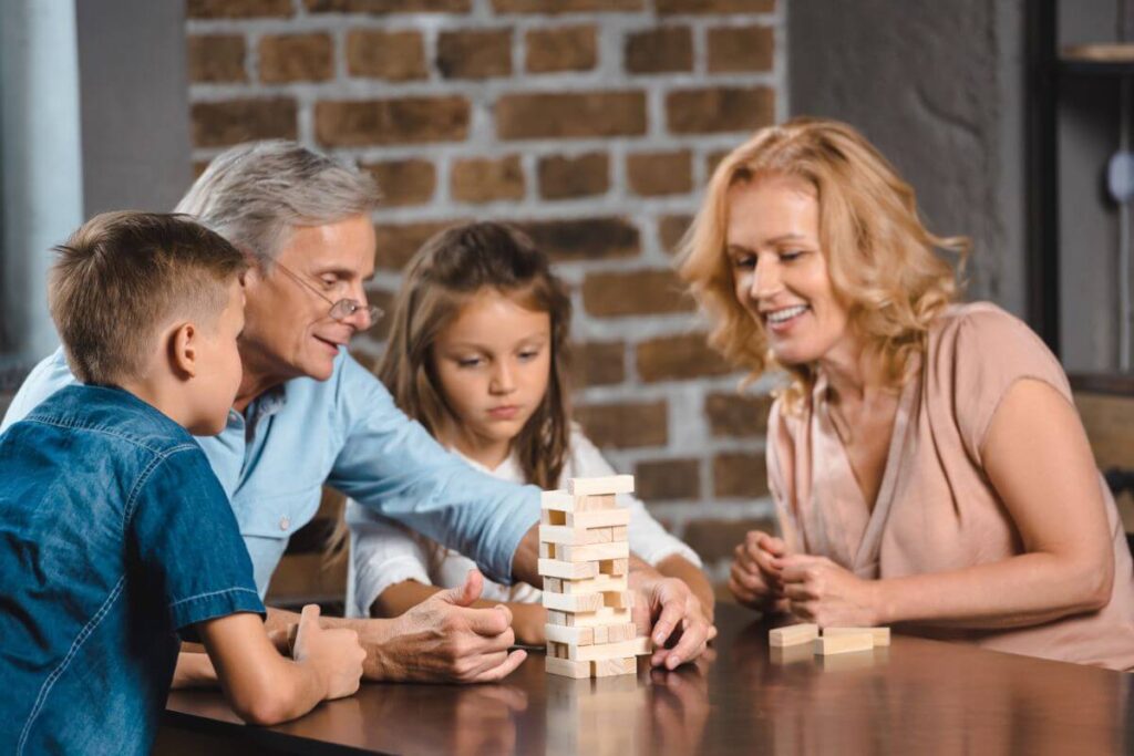 grandparents and their two grandchildren play a game together to avoid grandparent alienation