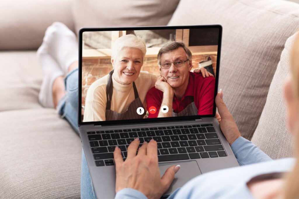 woman sitting on a sofa video chatting with her parents in another state