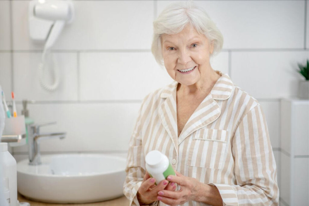 an elderly woman cheerfully starts getting ready for the day in her bathroom