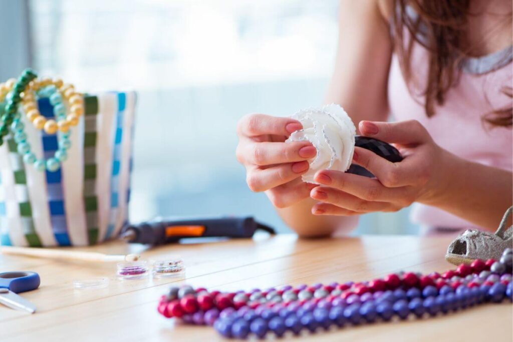 after learning minimalist lifestyle tips a women is making jewelry at a small table